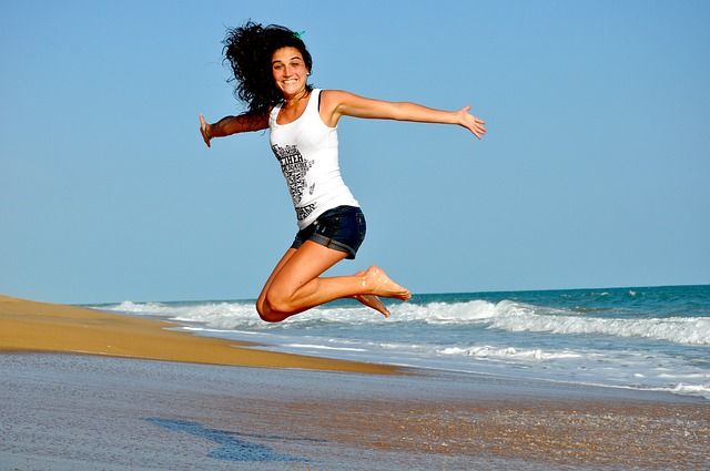 vrouw op strand springen sprong via Pixabay